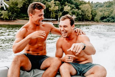 two men sitting on boat while laughing